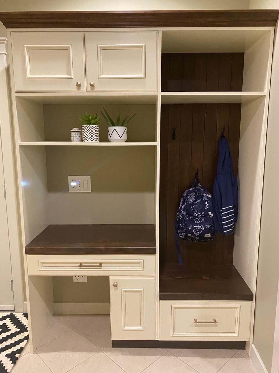 Custom mudroom entryway with decorative black hooks and dark wood accents