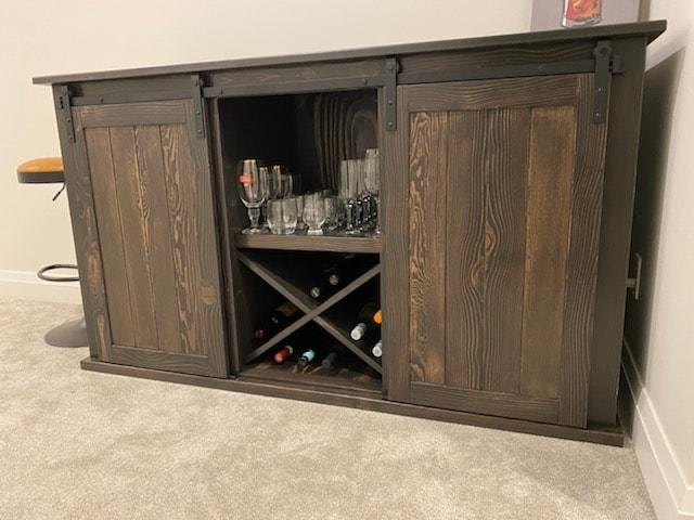 Dark barn door bar cabinet with wine rack and glass storage